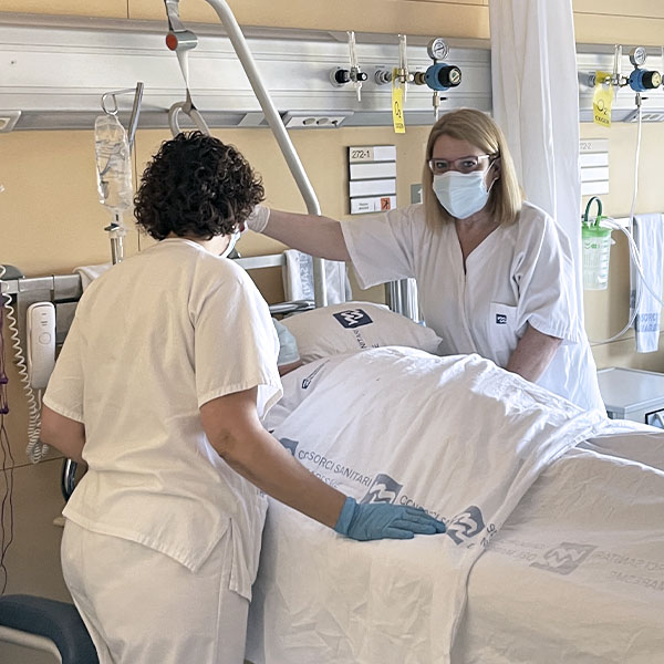Tècniques auxiliars d’infermeria atenent un pacient a planta